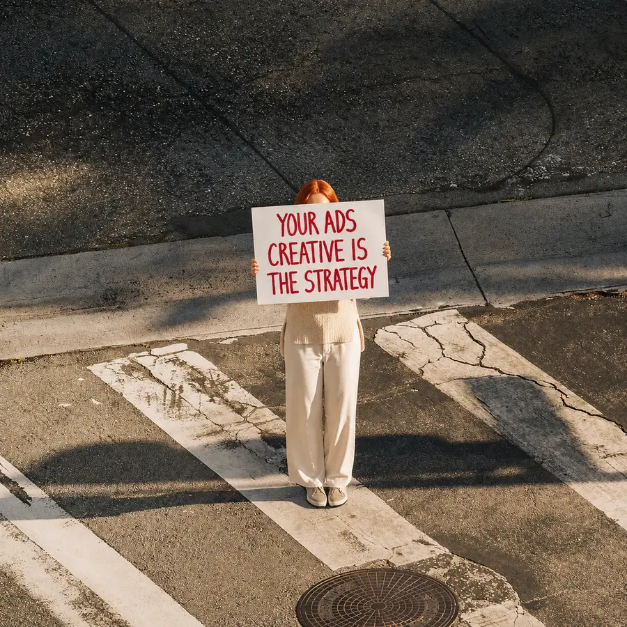 Emi holding a sign: your ads creative is the strategy